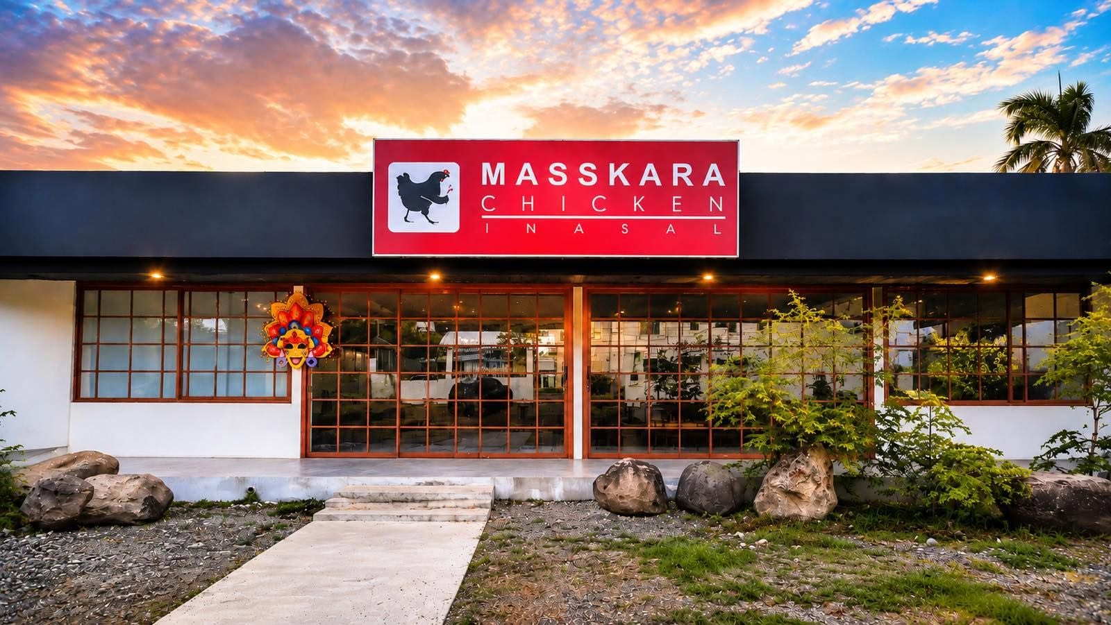 Masskara Chicken Inasal storefront at sunset, with a MassKara mask beside the entrance